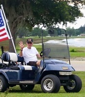 Coach Caudle waving from a golf cart